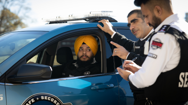 A security guard supervisor speaking with two security guards.