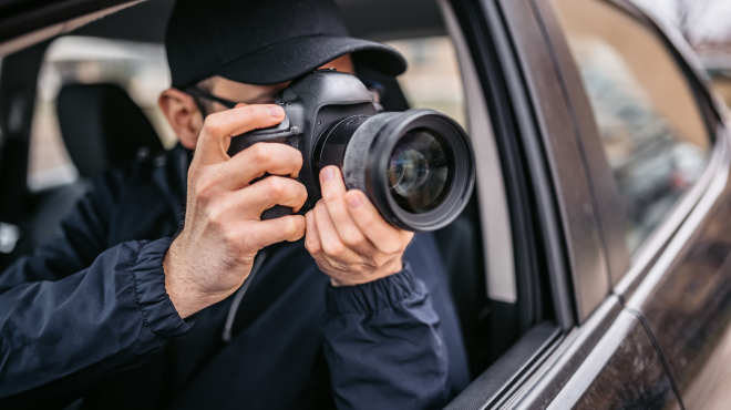 Private investigator taking a photo as part of collecting evidence.